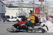 Young man on a high powered snowmobile stops at a traffic junction in Iqaluit. Nunavut. Canada. 2008