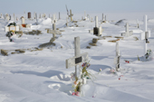Wind blown snow around the mostly Catholic graves in the cemetery in Igloolik. Nunavut. Canada. 2008
