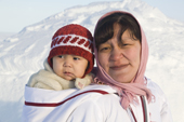 Lisa Ann Airut, an Inuit woman from Igloolik, carrying her baby in a traditional Baffin Island Parka. Igloolik, Nunavut, Canada. 2008
