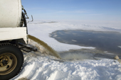Raw sewage pours from a tanker into a sewage lagoon on Igloolik Island. Nunavut, Canada. 2008