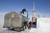Inuit workers fill a tanker from the frozen water reservoir near Igloolik. Nunavut, Canada. 2008