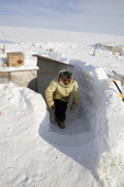 Jaipiti Palluq, an Inuit hunter, climbs the snow steps leading from the hut at his outpost camp on Igloolik Island. Nunavut, Canada. 2008