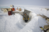 Abel Palluq, an Inuit boy, climbs the snow steps leading from the hut at his family's outpost camp on Igloolik Island. Nunavut, Canada. 2008