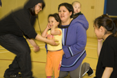 Inuit women & children enjoy watching a Hip hop dance class in the school gymnasium at Pangnirtung. Nunavut, Canada. 2008