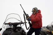 Inuit hunter Noah Metuq, prepares to sight his rifle at the start of a seal hunt in Cumberland Sound. Pangnirtung, Nunavut, Canada. 2008