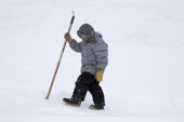 Aidan Metuk, an Inuit boy from Pangnirtung, checking a lead in the sea ice for baby seals. Nunavut, Canada. 2008