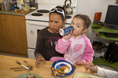 Nadia Metuq family sits with her young niece during lunch at their home in the Inuit community of Pangnirtung. Nunavut, Canada. 2008