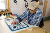 Inuit artist, Josea Manniapik, works on a stencil print at the Uqqurmiut Centre for Arts and Crafts in Pangnirtung. Nunavut, Canada. 2008