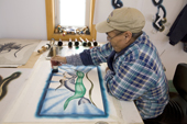 Inuit artist, Josea Manniapik, works on a stencil print at the Uqqurmiut Centre for Arts and Crafts in Pangnirtung. Nunavut, Canada. 2008