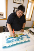 Inuit artist, Andrew Qappik, works on a stencil print at the Uqqurmiut Centre for Arts and Crafts in Pangnirtung. Nunavut, Canada. 2008