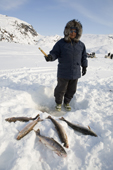 Joavee Alivakluk, an Inuit hunter, fishing through a hole in the ice for Arctic Char on a frozen lake near Pangnirtung. Nunavut, Canada. 2008
