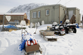 An Inuit hunter's home in Pangnirtung with snowmobiles & sleds outside and sealskins hanging up to dry. Nunavut, Canada. 2008