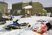 Brightly coloured snowmobiles outside Inuit hunters' homes in the community of Pangnirtung. Nunavut, Canada. 2008