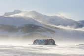 Wind drifting snow around a dining tent at Patriot Hills with Mount Fordell in the Independence Hills almost hidden by blowing snow. Antarctica