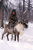 An Evenki man riding a draft reindeer in the forest. Evenkiya, Siberia, Russia. 1997