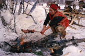 Olga Gilova, an Evenki woman cooking reindeer meat over an open fire. Evenkiya, Siberia, Russia. 1997