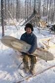 Victor Ivanovich, an Evenki reindeer herder, at his winter camp in the forest holds a pair of traditional Evenk reindeer skin covered skis. Surinda, Evenkiya, Central Siberia, Russia. 1997