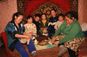 An Evenki family at their home in Surinda. Sewing and with puppy. Evenkiya, Central Siberia, Russia. 1997