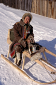 Marta, an Evenki woman, in traditional dress sitting on a sled. Evenkiya, Central Siberia, Russia. 1997