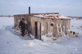 Vassily Selivanov, a Sami reindeer herder from Lovozero, carries firewood into his hut. Murmansk, NW Russia. 2005