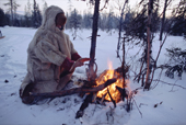 Olga Kirillova, a Sami woman from Lovozero, warms her hands by a fire during a break in a winter snowmobile journey. Murmansk, NW Russia. 2005