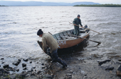 Sami men return to their summer camp in a wooden boat after checking their fishing nets near Lovozero. Kola Peninsula, NW Russia. 2005