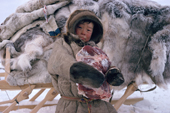Boris Serotetto, a Nenets boy, carrying reindeer meat for the family meal at a winter herders' camp. Yamal. Siberia. Russia.
