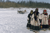 Nenets women in traditional dress watch reindeer racing at a Spring festival. Yamal, Siberia, Russia.