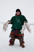 Pyotr Serotetto, a young Nenets men, holding some Muksun which he has caught in a fishing net set under the sea ice near. Seyakha, Yamal Peninsula, Northwest Siberia