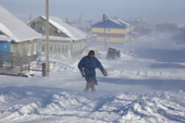 A Nenets man struggles to walk along the main street in village of Seyakha during a severe storm. Yamal Peninsula, Western Siberia, Russia