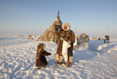 Jakov Vanuito, a Nenets reindeer herder, shows his daughter, Nenya, an Arctic fox he has caught near their winter camp on the Tambey Tundra. Yamal Peninsula, Western Siberia, Russia