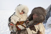 At their winter camp, Emma Vanuito, a Nenets woman, holds her daughter, Nenya. Tambey. Yamal Peninsula, Western Siberia, Russia.