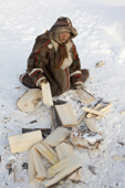 Nyaka, a 76 year old Nenets woman, chopping firewood at her family's winter camp near Tambey. Yamal Peninsula, Western Siberia, Russia