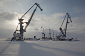 Cranes and drilling derricks near at the port in Sabetta in the South Tambey gas field. Yamal Peninsula, Western Siberia, Russia