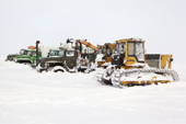 A bulldozer & trucks covered in snow after a storm at an exploratory gas drilling site in the South Tambey gas field. Yamal Peninsula, Western Siberia, Russia