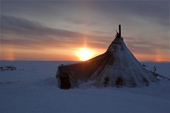 Sunset at a Nenets reindeer herders camp on the Tambey tundra showing a sun pillar and sun dogs (parhelia). Yamal Peninsula, Western Siberia, Russia