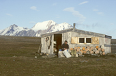 Trapper Louis Nielsen sorts bags of Eiderdown outside his hut, on the island of Eholmen, Spitsbergen.