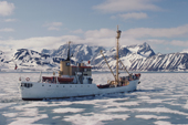 Tourist ship makes its way through melting sea ice in Hornsund Fjord, Spitsbergen